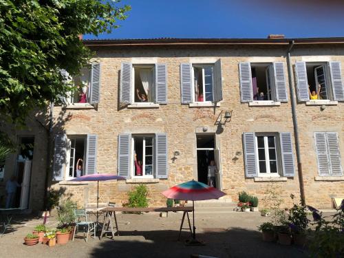two umbrellas in front of a building with open windows at La Maison d'Ambronay in Ambronay