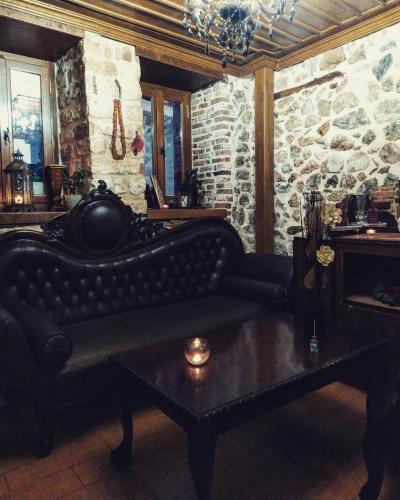 a living room with a black couch and a table at Pension Anapli in Nafplio