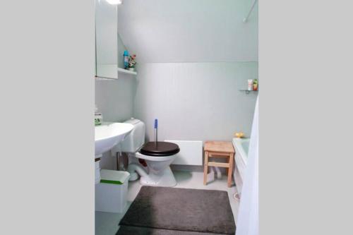 a white bathroom with a toilet and a sink at The Cozy Little House in Motala