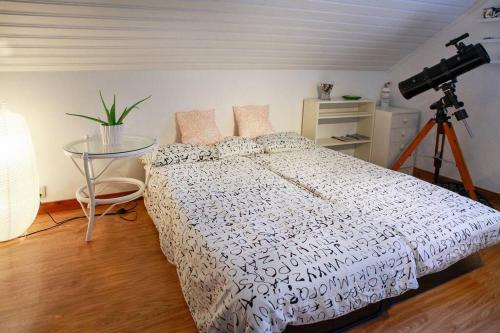 a bedroom with a bed with a camera on a tripod at The Cozy Little House in Motala