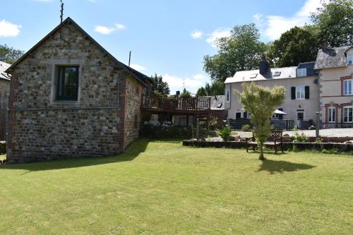 an old stone house with a grass yard at Gites in Le Neufbourg -Mortain in Le Neufbourg