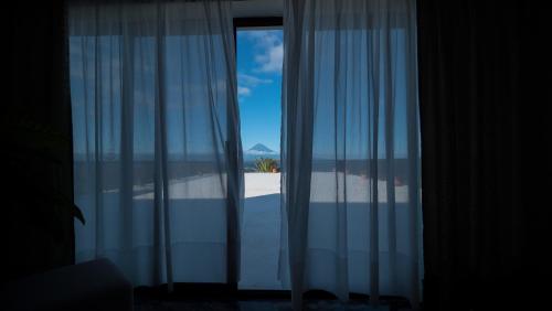 
a view through a glass window of a sunset at Hotel Sao Jorge Garden in Velas
