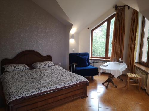 a bedroom with a bed and a chair and a table at Hotel Edem in Tsaghkadzor
