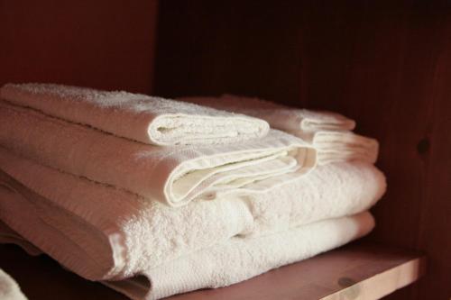 a stack of white towels sitting on a shelf at Marnabianca Apartment in Realmonte