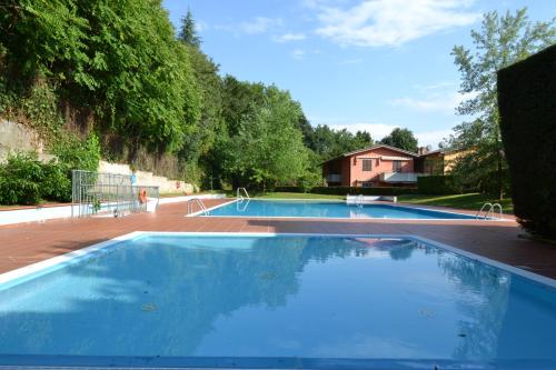 a large swimming pool with blue water in a yard at Rosalinde House in Colà di Lazise