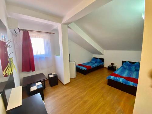 a large room with two beds and a window at Iorga's House in Eforie Nord