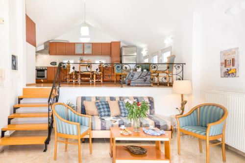 a living room with a couch and a table and chairs at Villa Frati Gorge in Fratíon