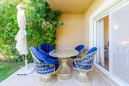 a patio with a table and chairs and an umbrella at Casa Mapie - Boavista Resort in Lagos