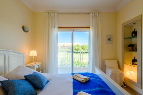 a bedroom with a bed and a large window at Casa Mapie - Boavista Resort in Lagos
