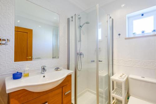 a white bathroom with a sink and a shower at Casa Mapie - Boavista Resort in Lagos