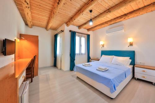 Dormitorio con cama, escritorio y TV en St. Nicholas Pension, en Patara