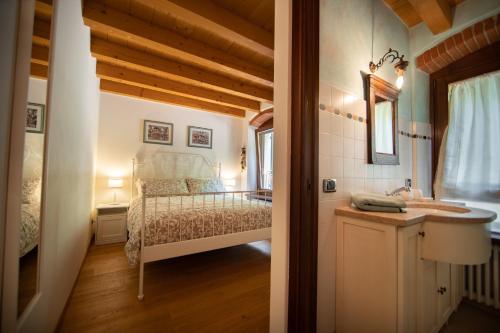 a bathroom with a bed and a sink in a room at Villa Vitis in Negrar