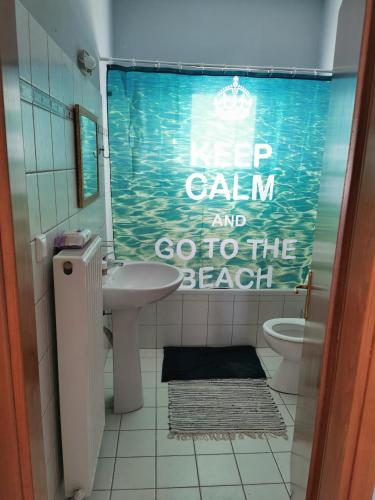 a bathroom with a toilet and a sign on the shower curtain at Elli's House in Keramoti