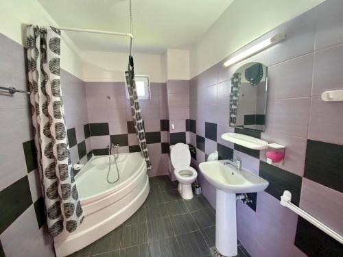 a bathroom with a tub and a sink and a toilet at Iorga's House in Eforie Nord