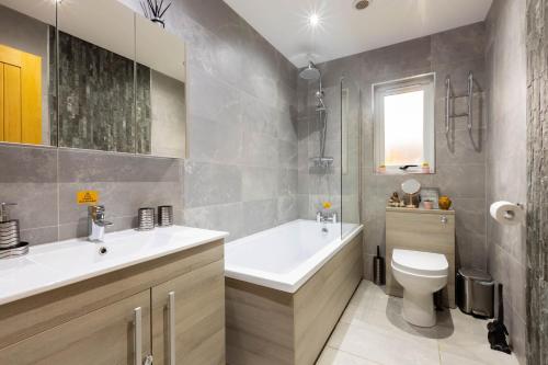 een badkamer met een bad, een toilet en een wastafel bij Settlers Lodge in Otterburn