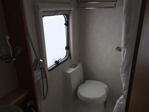 a small bathroom with a toilet and a window at Four Berth Motorhome Isle of Lewis in Stornoway