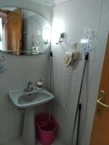 a bathroom with a sink and a mirror at Poseidon rooms in Nea Vrasna