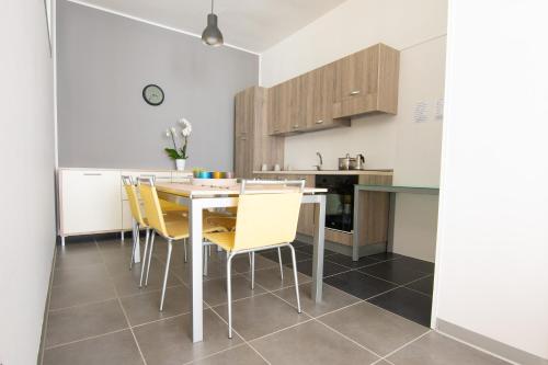 a kitchen and dining room with a table and yellow chairs at CIVICO33 in Rocca Imperiale