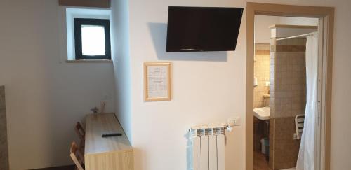 a room with a table and a television on a wall at Agriturismo Il Casale Pica in Posta