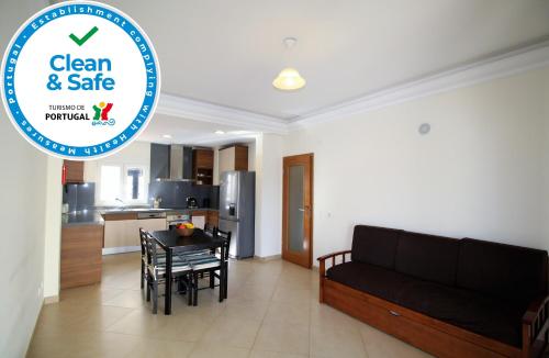 a living room with a black couch and a table at T1 Praia da Rocha/1ª linha in Portimão