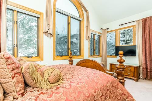 1 dormitorio con 1 cama grande y ventanas en Cimarron Mountain Retreat, en Telluride