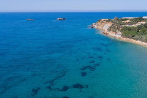an aerial view of a beach with rocks in the water at Villa Eternity, Ai Helis Kefalonia in Kefallonia