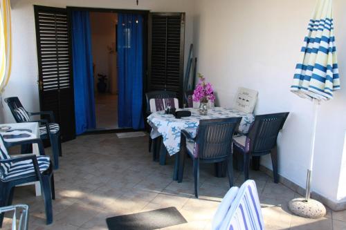 a table with chairs and a blue and white table cloth at Apartments Brac Mirca in Mirce