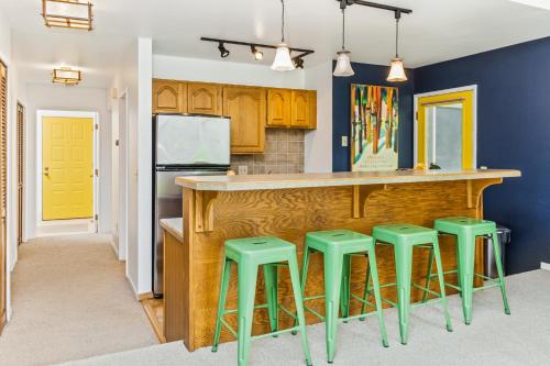 a kitchen with a bar with green stools at Shimmy Shack at 101-A Snowbird in Girdwood