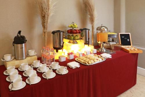 a table with cups and saucers and food on it at Holiday Inn Hotel & Suites Centro Historico by IHG in Guadalajara