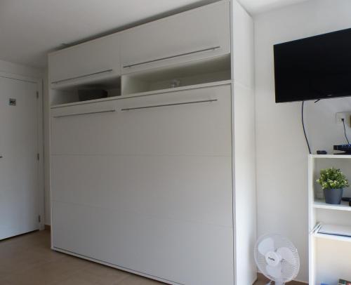 a white closet in a room with a flat screen tv at Les terrasses de Malmedy Studio 333 Yellow Grey in Malmedy