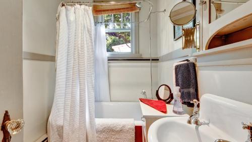 a bathroom with a sink and a tub and a window at San Jose Cottage in Victoria