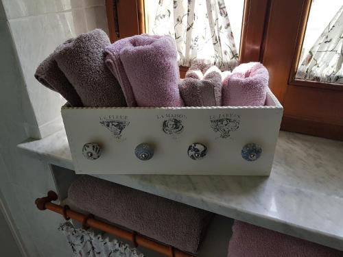 una scatola di asciugamani su una mensola in bagno di La Casa nel Chianti a Greve in Chianti