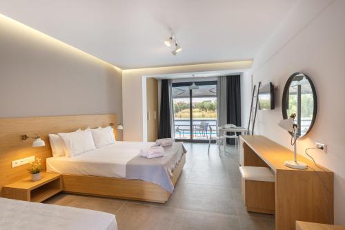 a hotel room with a bed and a mirror at ISALOS GERAKiNi in Yerakiní