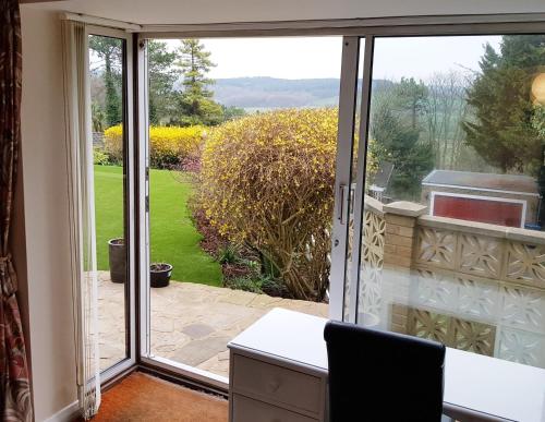 a sliding glass door with a view of a garden at Studio Garden Flat in Warlingham