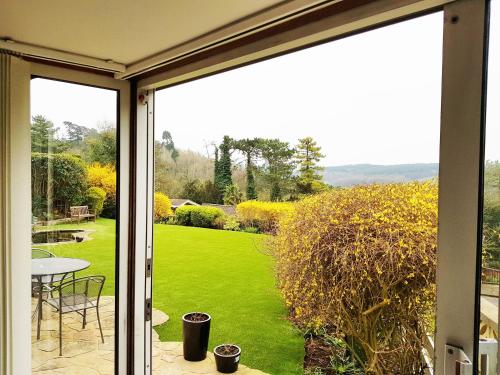 una puerta corredera de cristal con vistas al jardín en Studio Garden Flat, en Warlingham