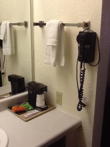 a phone hanging on a wall in a bathroom at Super 8 by Wyndham Kennett in Kennett