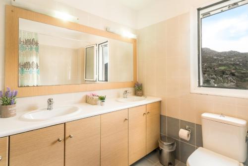 a bathroom with two sinks and a mirror at Villa Frati Gorge in Fratíon