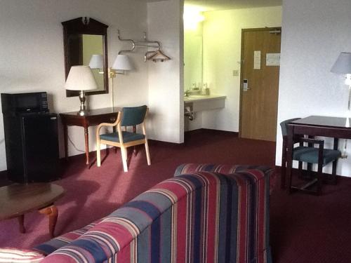 a hotel room with a couch and a table at Super 8 by Wyndham Kennett in Kennett
