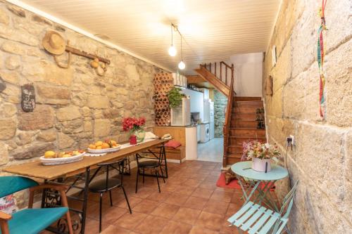 a room with a table and chairs and a stone wall at Albergue Casa de Abreu in Redondela