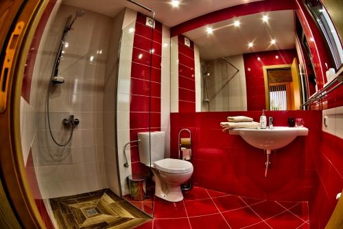 een rode badkamer met een toilet en een wastafel bij Holiday Home Marta in Dobrevtsi