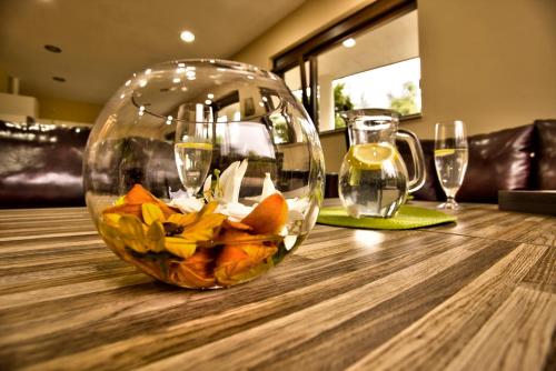 a glass bowl on top of a wooden table with wine glasses at Holiday Home Marta in Dobrevtsi