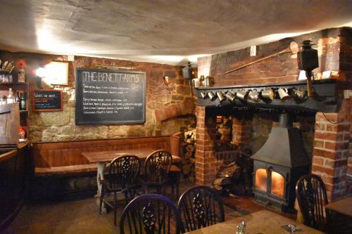 a restaurant with a fireplace and a table and chairs at The Benett Arms in Shaftesbury