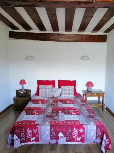 a bedroom with a bed with a red and white blanket at Maison de l'Epine -spa- Versant du soleil in Granier