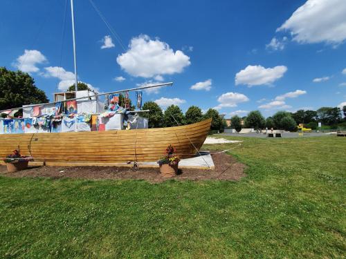 a large wooden boat in a park with a field at JUFA Hotel im Brückenkopfpark - Jülich in Jülich