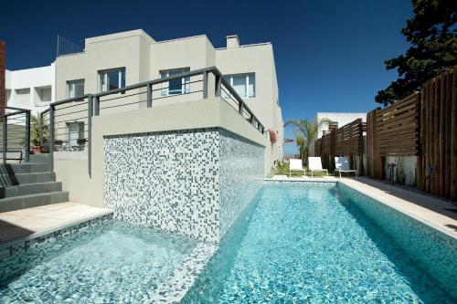 a house with a swimming pool in front of a house at Rambla Apartamentos in Montevideo