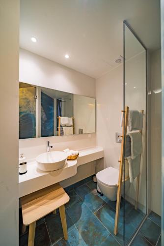 a bathroom with a sink and a toilet at Kyma Couples Getaway in Stalís