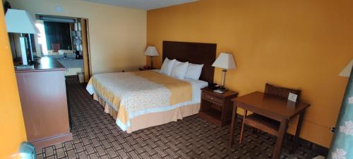 a hotel room with a bed and a desk and a bed sidx sidx sidx sidx at Days Inn by Wyndham Dickson in Dickson
