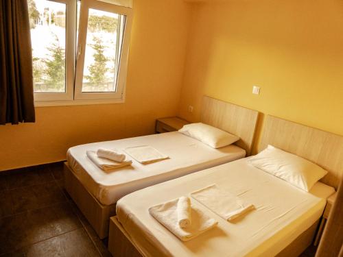 two beds in a small room with a window at Ktima Argiri in Ormos Panagias