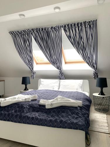 a bedroom with a bed and two windows at Willa 4 Pory Roku & Uznam in Świnoujście