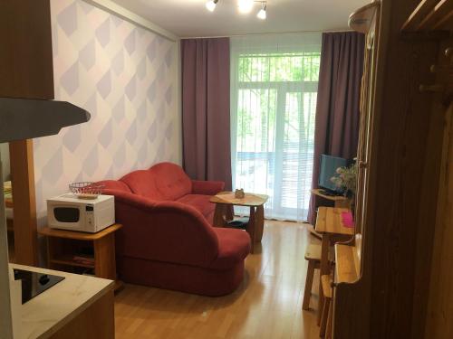 a living room with a red couch and a microwave at Apartmány Bea Donovaly in Donovaly